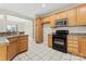 Spacious kitchen with wood cabinets, black appliances, tile floor, and breakfast bar, offering ample storage at 145 Mcbride Dr, Rockwell, NC 28138