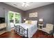 Cozy bedroom featuring a wrought iron bed frame and serene gray walls and cherry floors at 1800 Robbins Meadows Dr, Waxhaw, NC 28173