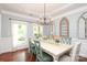 Bright dining room featuring a modern chandelier, an elegant table setting, and large decorative windows at 1800 Robbins Meadows Dr, Waxhaw, NC 28173