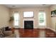 Living room with hardwood floors, a fireplace with tv mounted above, and large windows at 1800 Robbins Meadows Dr, Waxhaw, NC 28173