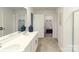 Bathroom featuring double vanity sinks with white cabinetry and tile floor with view into walk-in closet at 200 Parker Claire Ln, Kings Mountain, NC 28086