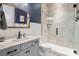 Modern bathroom with a glass-enclosed shower, gray vanity, stylish mirror, and blue accent wall at 2150 Paddlers Cove Dr, Clover, SC 29710