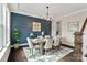 Elegant dining room with a wood table, upholstered chairs, stylish chandelier, and a navy accent wall at 2150 Paddlers Cove Dr, Clover, SC 29710