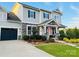 Stylish two-story home with a dark-blue garage door, green lawn, stone accents, and lovely landscaping at 2150 Paddlers Cove Dr, Clover, SC 29710