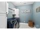 Well-organized laundry room with stylish blue washer and dryer, white cabinets, and decorative accents at 2150 Paddlers Cove Dr, Clover, SC 29710