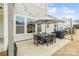 Outdoor patio featuring a dining set, umbrella, and grill, reflecting the surrounding homes and sky at 2150 Paddlers Cove Dr, Clover, SC 29710