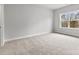 Spacious carpeted bedroom with neutral walls and large window at 3041 Tramore Dr, Harrisburg, NC 28075