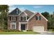 A brick two-story home is complimented by stone, an attached garage and professional landscaping at 3041 Tramore Dr, Harrisburg, NC 28075