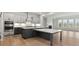 A gray and white kitchen is featured with a view of the living room and natural lighting at 3041 Tramore Dr, Harrisburg, NC 28075