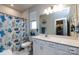 Bright bathroom features a blue-themed shower curtain, white vanity with ample storage, and a modern sink at 3100 Cheyney Park Dr, Charlotte, NC 28269