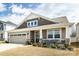 Charming home featuring a two-car garage, stone accents, well-maintained lawn, and a cozy front porch at 3100 Cheyney Park Dr, Charlotte, NC 28269