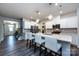 Modern kitchen with white cabinets, stainless steel appliances, an island with pendant lighting, and gray wood floors at 3100 Cheyney Park Dr, Charlotte, NC 28269