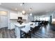 Open-concept kitchen with white cabinets, pendant lights, an island, and stainless steel appliances, seamlessly connecting to the living space at 3100 Cheyney Park Dr, Charlotte, NC 28269