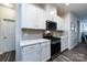 Modern kitchen featuring stainless steel appliances, white cabinets, and gray wood floors, creating a sleek design at 3100 Cheyney Park Dr, Charlotte, NC 28269