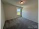 A carpeted bedroom features a window view and neutral walls at 317 Maidstone Dr # 57, Monroe, NC 28110