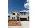 Charming two-story home with a two-car garage and neutral-colored siding, and black shutters under a bright blue sky at 317 Maidstone Dr # 57, Monroe, NC 28110
