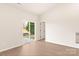 Empty room featuring sliding glass door, beige walls, and wood-look flooring at 3246 Maple Ridge Dr, Gastonia, NC 28052