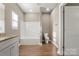 Bright bathroom features a bathtub with white tile, modern toilet, and stylish flooring at 325 East St, Heath Springs, SC 29058