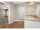 Bathroom with dual sinks, granite countertop, and an open doorway to an adjoining room and closet at 325 East St, Heath Springs, SC 29058