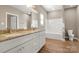 Bathroom showcasing a double vanity with granite countertop and modern fixtures, plus a bathtub with white tile surround at 325 East St, Heath Springs, SC 29058