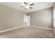 Bright bedroom with neutral walls, ceiling fan, plush carpeting, and natural light filtering through the windows at 325 East St, Heath Springs, SC 29058