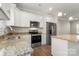 Modern kitchen with stainless steel appliances, granite counters, and white cabinets at 325 East St, Heath Springs, SC 29058