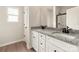 Bathroom featuring dual sinks, granite countertops, white cabinets, and a glass-enclosed shower at 3319 Burberry Dr, Gastonia, NC 28052