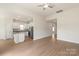 Open-concept living room showcasing hardwood floors, a ceiling fan, and seamless flow into the kitchen at 3335 Burberry Dr, Gastonia, NC 28052