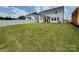 View of a well-maintained backyard featuring a large, green lawn, white fencing and a neighboring home at 346 Knotty Wood Dr # 71, Monroe, NC 28110