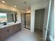 View of a bright bathroom featuring double vanity, glass-enclosed shower and a walk-in closet at 346 Knotty Wood Dr # 71, Monroe, NC 28110