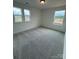 A carpeted bedroom featuring three windows offering views of the neighborhood at 346 Knotty Wood Dr # 71, Monroe, NC 28110