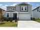 Charming two-story home with a two-car garage, blue door, manicured lawn and stone accents at 346 Knotty Wood Dr # 71, Monroe, NC 28110