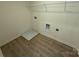 Dedicated laundry area with wood look floors ready for washer dryer and organizing shelves at 346 Knotty Wood Dr # 71, Monroe, NC 28110