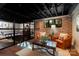 Cozy basement lounge with exposed brick walls, hardwood floors, and a ping pong table visible through a glass partition at 4313 Kingswood Rd, Charlotte, NC 28226