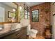 Stylish bathroom featuring a brick accent wall, vessel sink, and modern fixtures at 4313 Kingswood Rd, Charlotte, NC 28226