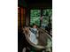This bathroom features exposed brick and lots of windows with views of the wooded lot and a unique stand alone tub at 4313 Kingswood Rd, Charlotte, NC 28226