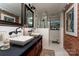 Elegant bathroom with a brick accent wall, double vanity, and walk-in shower at 4313 Kingswood Rd, Charlotte, NC 28226