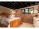 Comfortable bedroom with exposed brick wall and a window, complemented by carpeted floors and neutral tones at 4313 Kingswood Rd, Charlotte, NC 28226