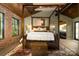 This bedroom features exposed brick, beautiful backyard views, a canopy bed, and an en-suite bathroom at 4313 Kingswood Rd, Charlotte, NC 28226