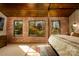 This bedroom features exposed brick, beautiful backyard views through black framed windows, and a canopy bed at 4313 Kingswood Rd, Charlotte, NC 28226