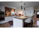 Bright kitchen featuring a brick accent wall, white cabinetry, and a center island with bar seating at 4313 Kingswood Rd, Charlotte, NC 28226