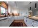 Bright kitchen showcasing a brick accent wall, white cabinetry, stainless steel appliances, and hardwood flooring at 4313 Kingswood Rd, Charlotte, NC 28226