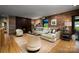 Cozy living room with a brick accent wall, fireplace, comfortable seating, and hardwood floors at 4313 Kingswood Rd, Charlotte, NC 28226