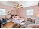 Pink bedroom featuring wood floors, ceiling fan, a comfortable seating area, and natural light from multiple windows at 536 Shiloh Church Rd, Hickory, NC 28601