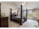 Elegant main bedroom with a four-poster bed and natural light from the windows at 6019 Timbertop Ln, Charlotte, NC 28215