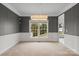 Bright dining room with gray walls, white wainscoting, large windows, and a modern chandelier at 6019 Timbertop Ln, Charlotte, NC 28215