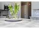 Close-up of a marble kitchen island with decorative flowers, complemented by sleek gray cabinetry at 6019 Timbertop Ln, Charlotte, NC 28215