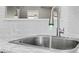 A close up of a stainless steel kitchen sink with running water and white subway tile background at 6019 Timbertop Ln, Charlotte, NC 28215