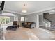 Open living room with stylish seating, modern lighting, and seamless transition to the staircase at 6019 Timbertop Ln, Charlotte, NC 28215