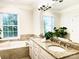 Bright bathroom featuring a soaking tub, double vanity with granite counters, and a large window at 735 Amalfi Dr, Davidson, NC 28036